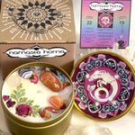 The Capricorn Crystal Candle opened with the lid to the right of it. The packaging of the Capricorn Crystal Candle is behind the candle next to a card.