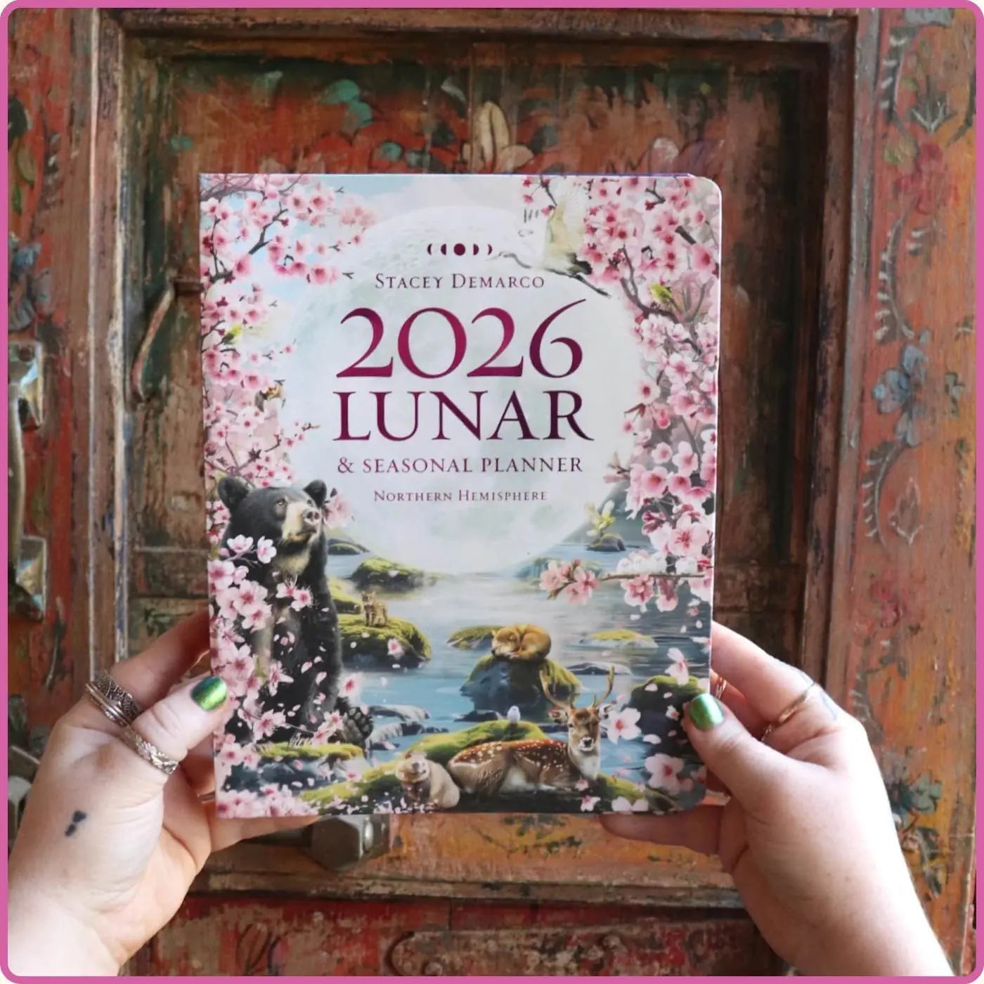 2026 Lunar & Seasonal Planner held by hands in front of a decorative wooden box.
