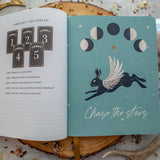 Open book with astrological design and text on a textured surface