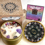 The Pisces Crystal Candle opened with the lid to the right of it. The packaging of the Pisces Crystal Candle is behind the candle next to a card.