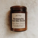 The Sympathy for the Devil candle on a white fluffy surface.