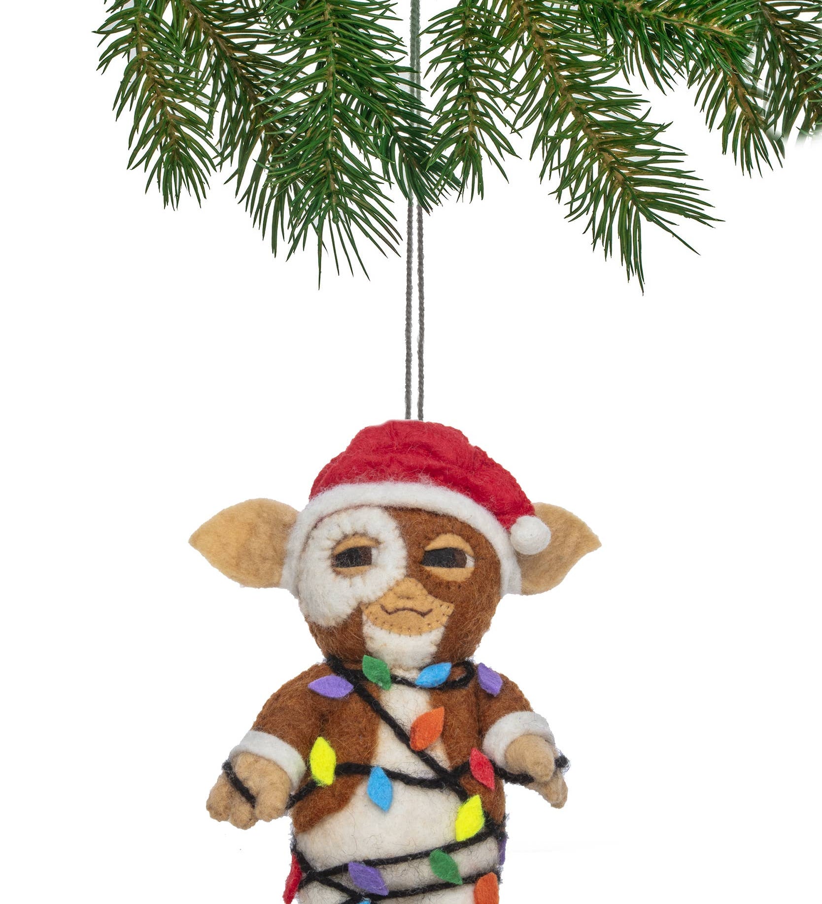 Felt ornament of a character wrapped in Christmas lights hanging from a tree branch.