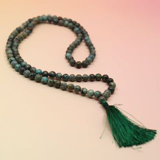 African Turquoise 108 Mala Necklace on pink and orange background