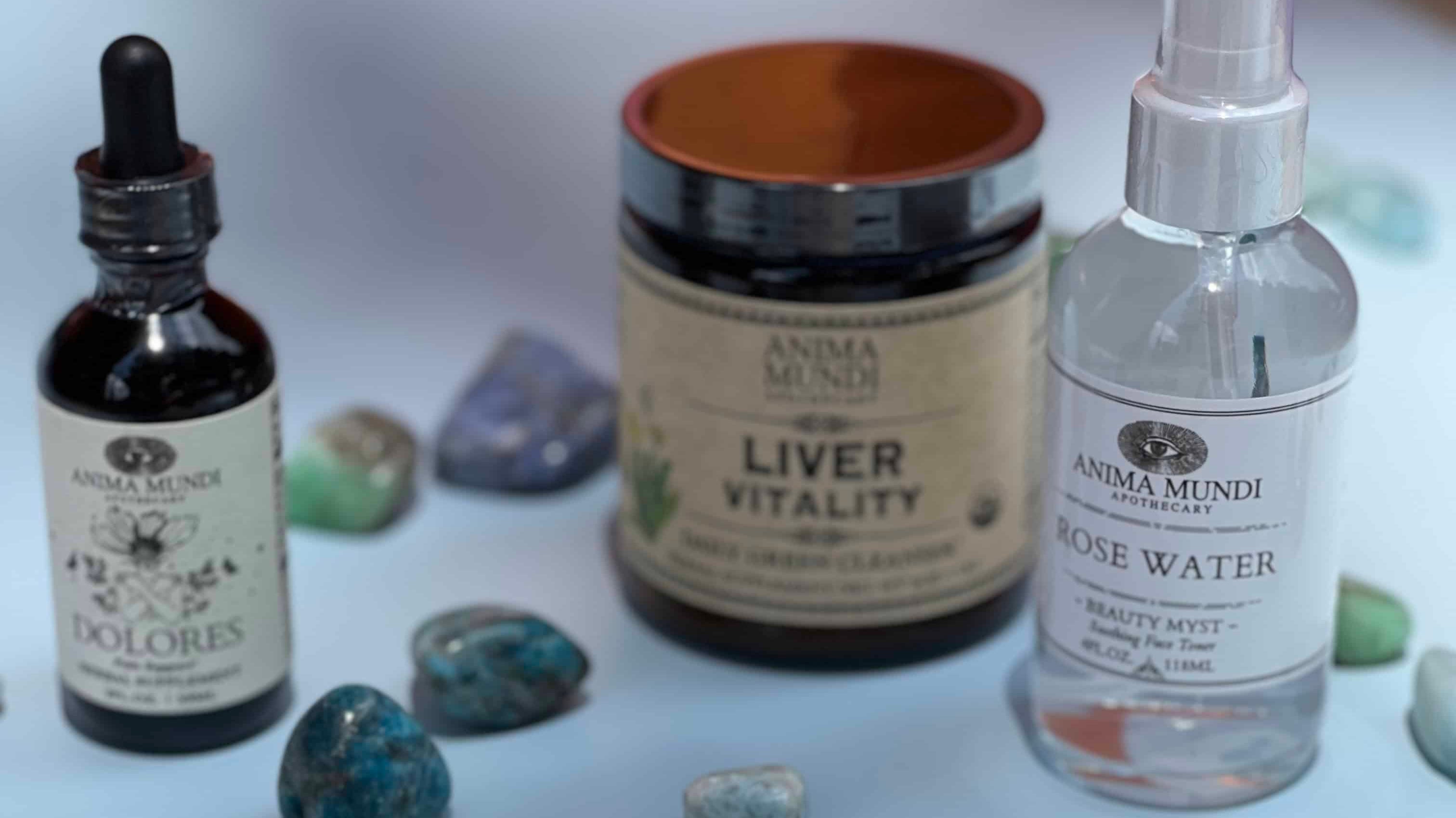 Herbal remedies and crystals on a light surface with 'Anima Mundi' branding.