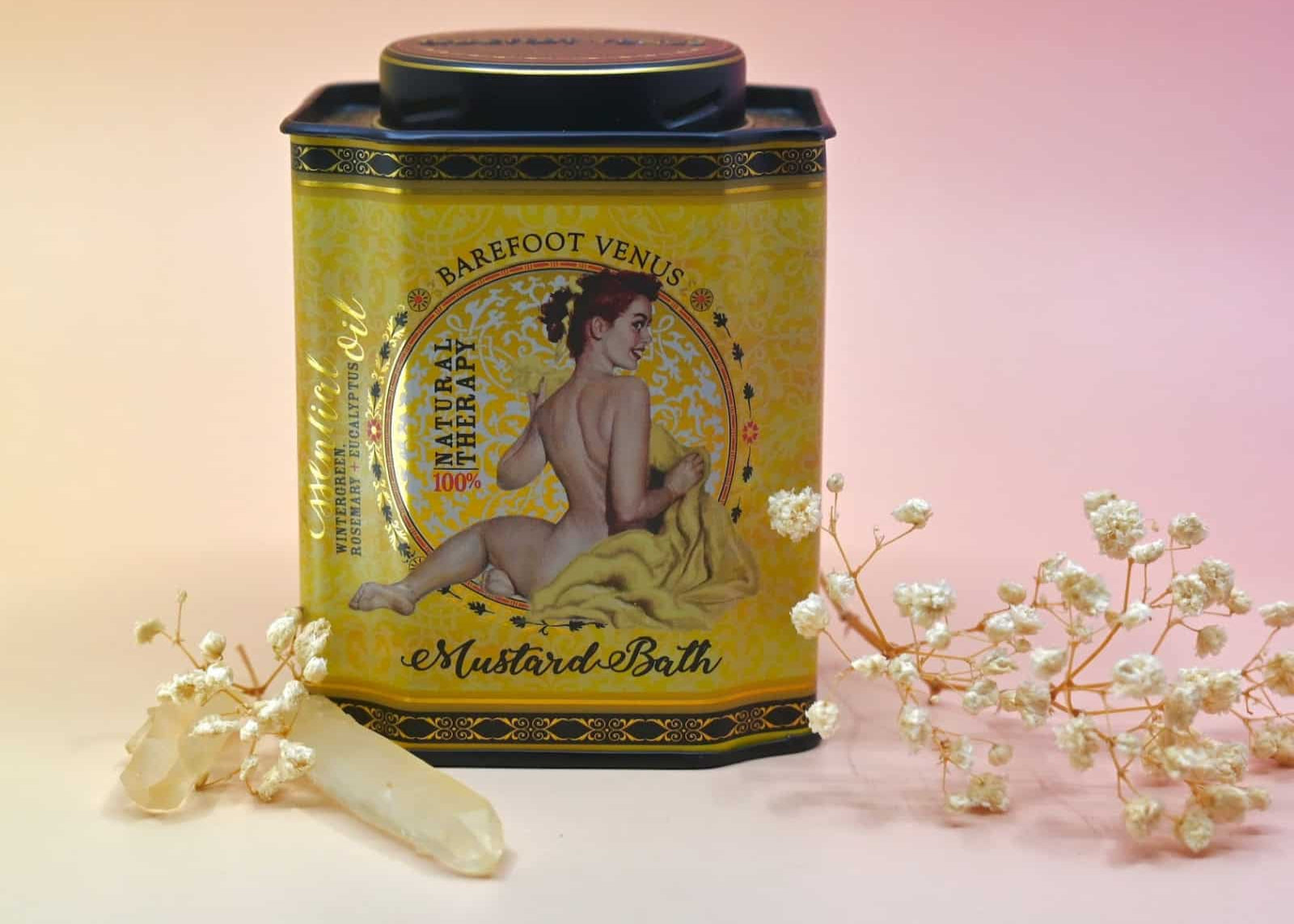 Yellow tin labeled 'Barefoot Venus' with floral decorations on a gradient background