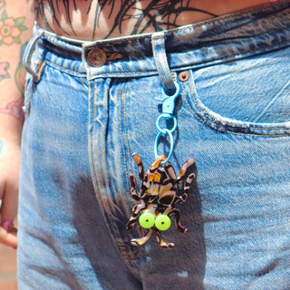Bug keychain clipped to denim jeans