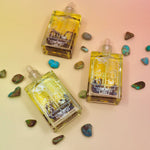 Blue Lotus Oil laid flat on a pastel pink background with turquoise stones around