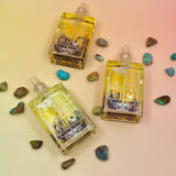 Blue Lotus Oil laid flat on a pastel pink background with turquoise stones around