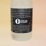 Bottle with a label for '1% for the Planet' on a beige background