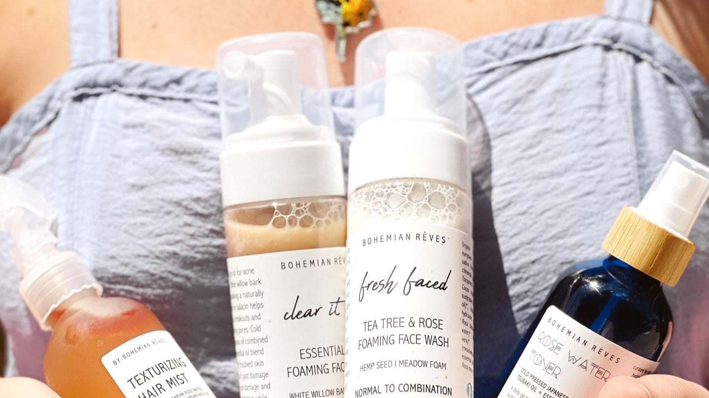 Person holding various skincare products from Bohemian Reves by the Sea.