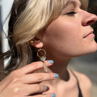 A woman wearing the Brass Quartz Crystal Triangle 2 inch. Earrings.