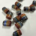Multiple layered chakra cylinder tumbled stones on a white background, each featuring stacked colorful crystal layers