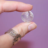 Hand holding a clear quartz marble