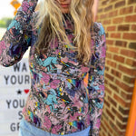 Model running hand through hair in colorful long sleeve high neck fantasy top