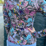 model standing in front of blue wall showing colorful detailed back print