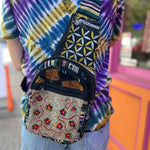 Close-up of floral embroidered cotton crossbody bag with woven herringbone base