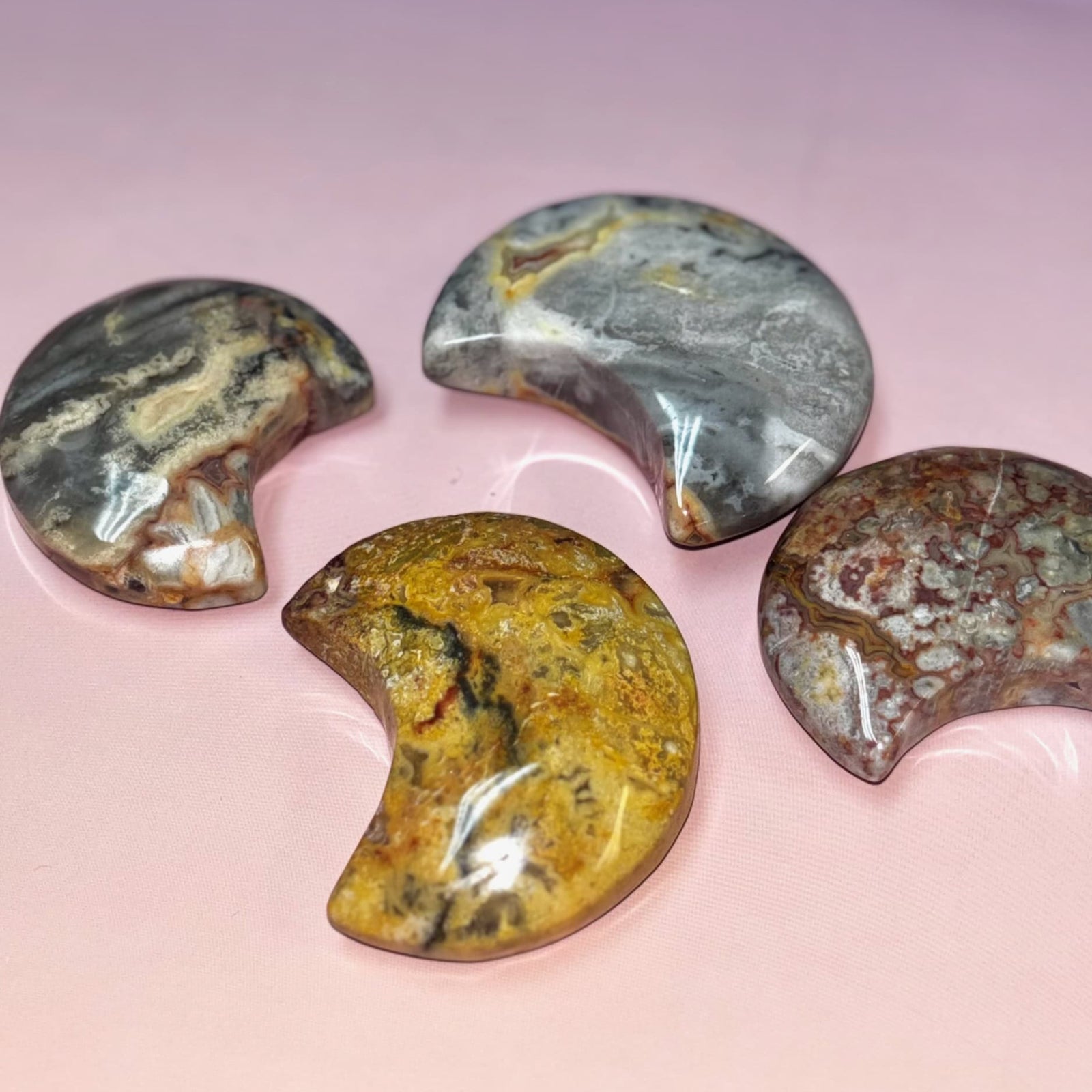 Four semi-precious stones on a pink background
