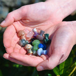 Mini Crystal Gemstone Mushrooms over grass in ladies cupped hands