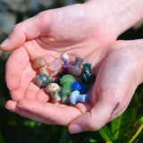 Mini Crystal Gemstone Mushrooms over grass in ladies cupped hands