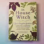 "The House Witch" book on a pink and blue background, showing off the front cover.