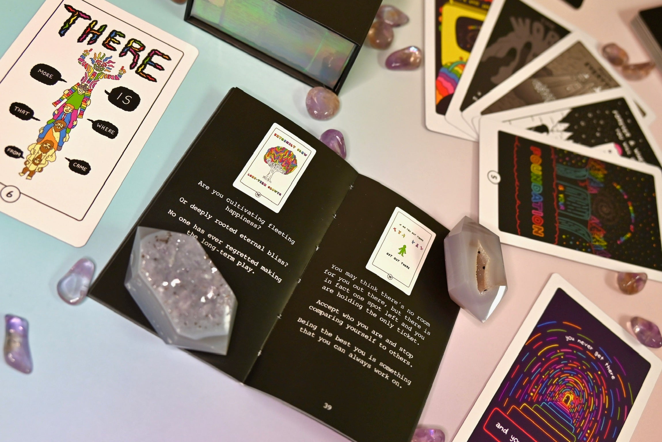 The contents of the Rainbow Brainskull Oracle Deck on a pink and blue background.