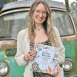 Someone holding the The "Green Witch's Coloring Book".