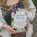 Someone holding the "The House Witch" book.