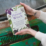 Someone holding the "The House Witch" book.