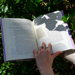 Someone holding the "The Green Witch's Garden" book showing off its pages.