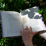 Someone holding the "The Green Witch's Garden" book showing off its pages.