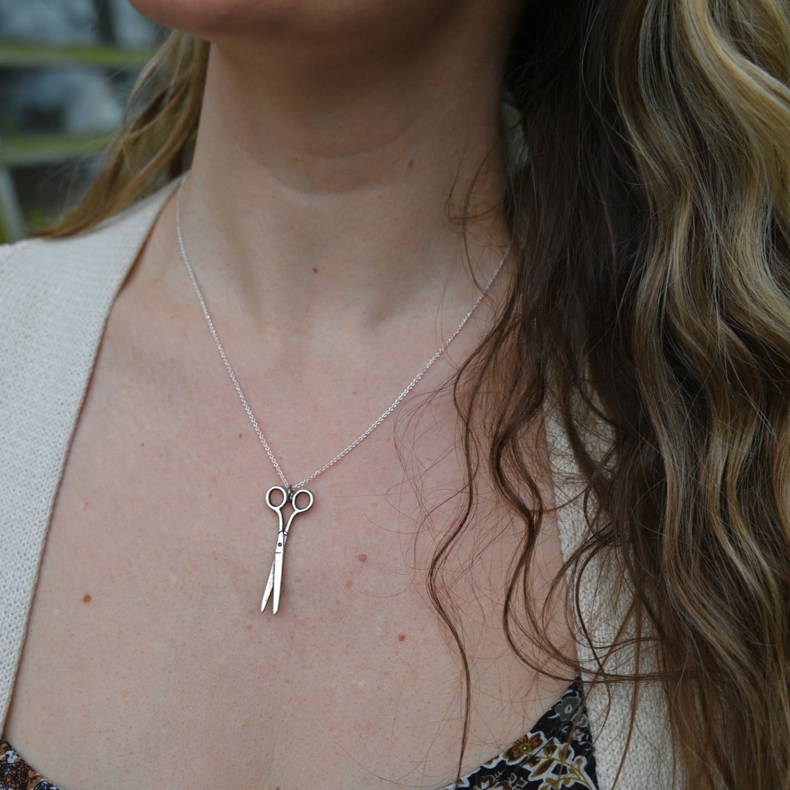 An up-close image of someone wearing the Vintage Silver Scissors Charm Necklace.