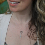 An up-close image of someone wearing the Vintage Silver Scissors Charm Necklace.
