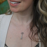 An up-close image of someone wearing the Vintage Silver Scissors Charm Necklace.