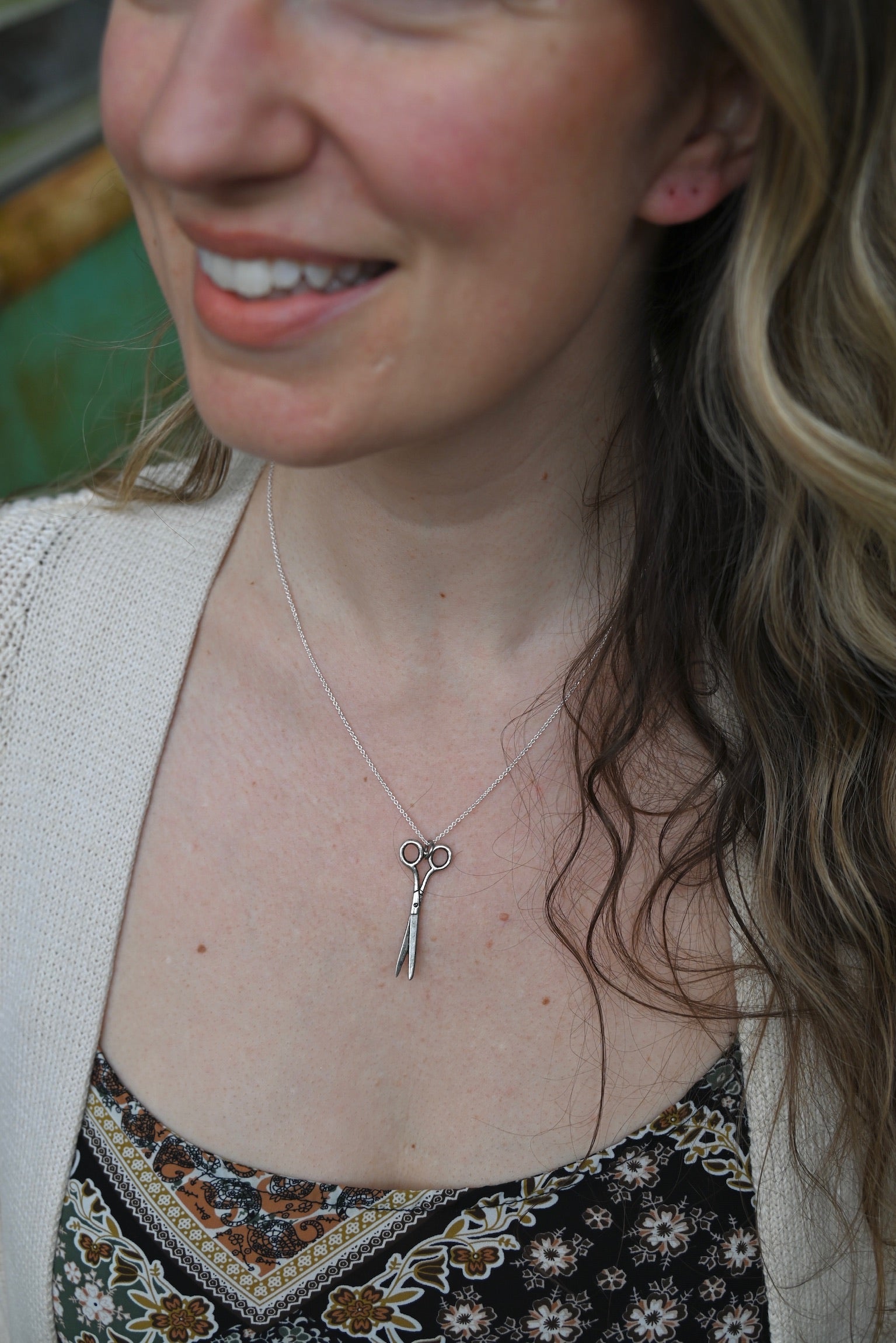 An up-close image of someone wearing the Vintage Silver Scissors Charm Necklace.