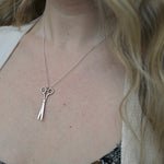 An up-close image of someone wearing the Vintage Silver Scissors Charm Necklace.