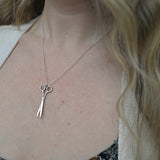 An up-close image of someone wearing the Vintage Silver Scissors Charm Necklace.
