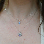 Someone wearing the Sterling Silver Purple Evil Eye Necklace with Paperclip Chain.