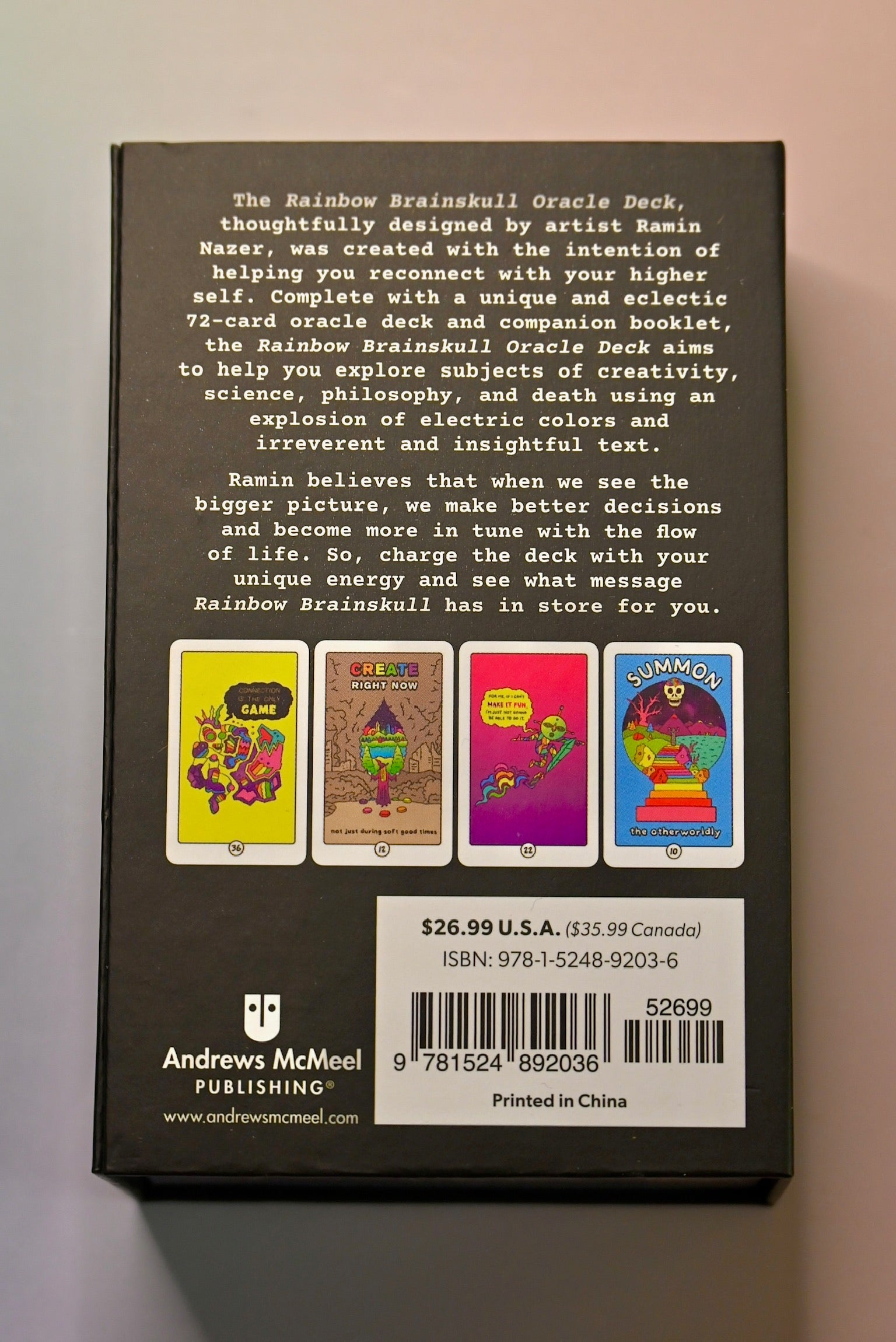 The back of the Rainbow Brainskull Oracle Deck on a pink and blue background.