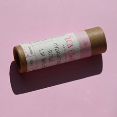 The Rose Lip Balm on a pink background.