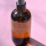 The P.F. Candle Co. - Golden Coast - 7.75 fl oz Room & Linen Spray on a pink background.