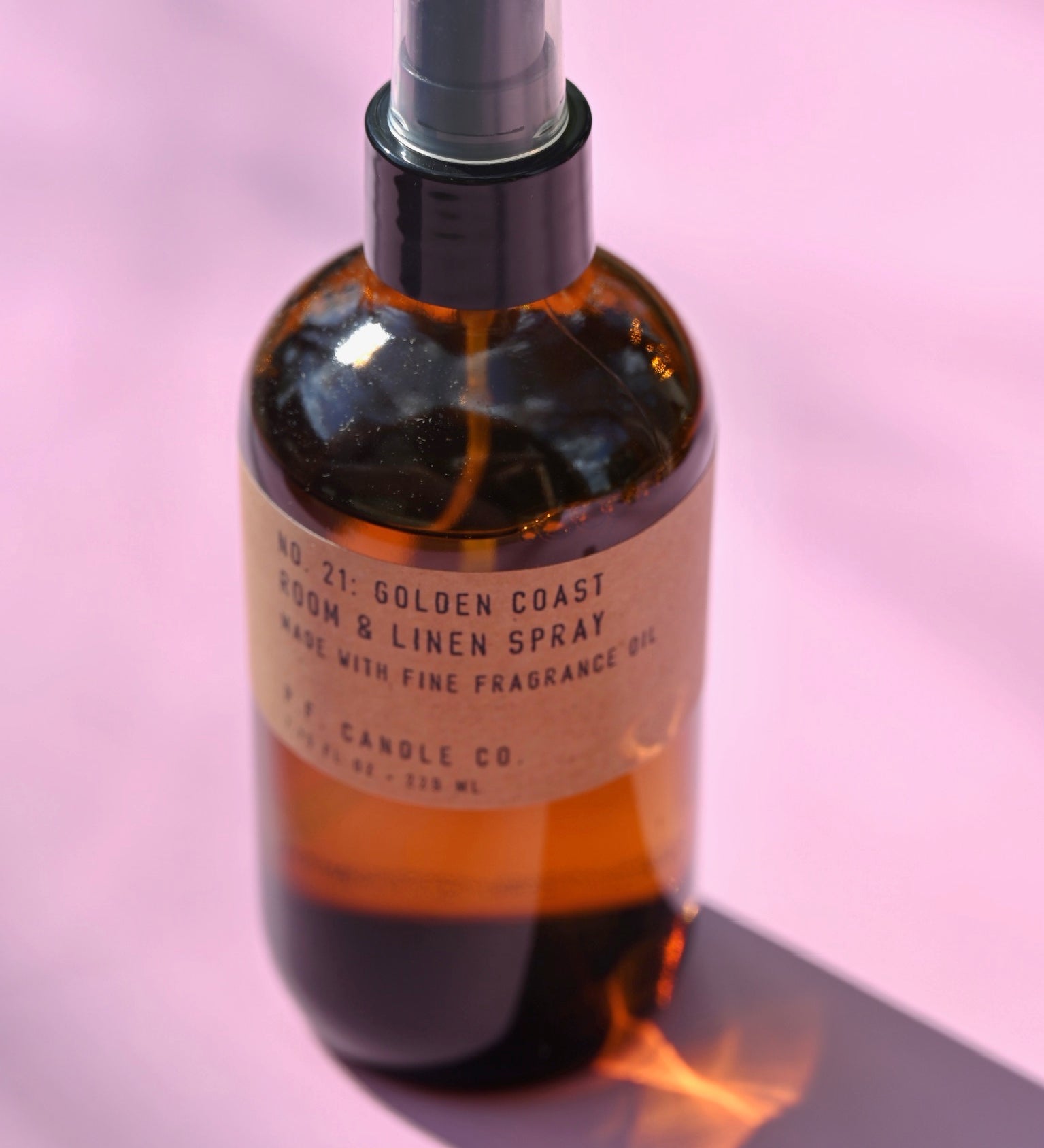 The P.F. Candle Co. - Golden Coast - 7.75 fl oz Room & Linen Spray on a pink background.