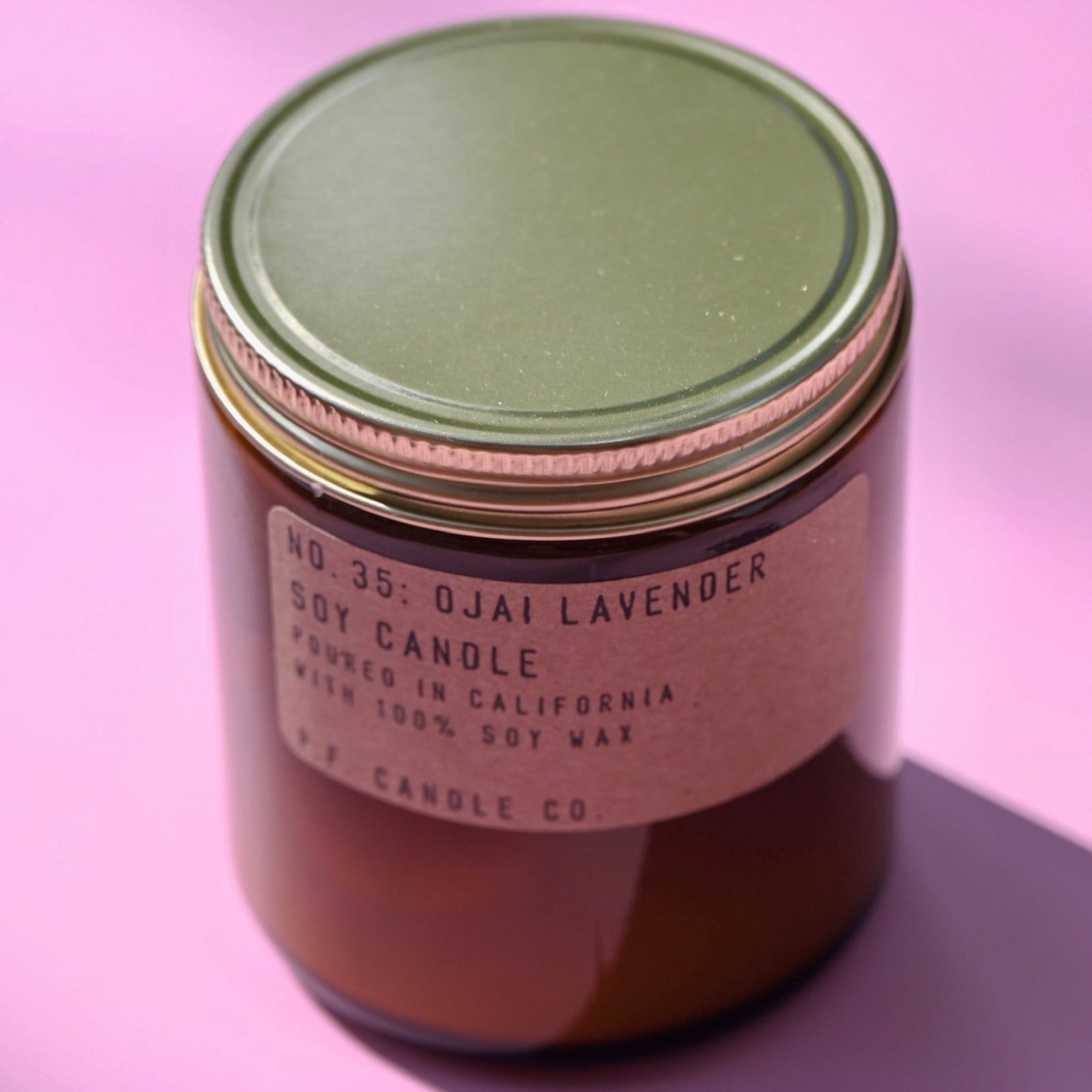 The P.F. Candle Co. Ojai Lavender - 7.2 oz Standard Soy Candle on a pink background.