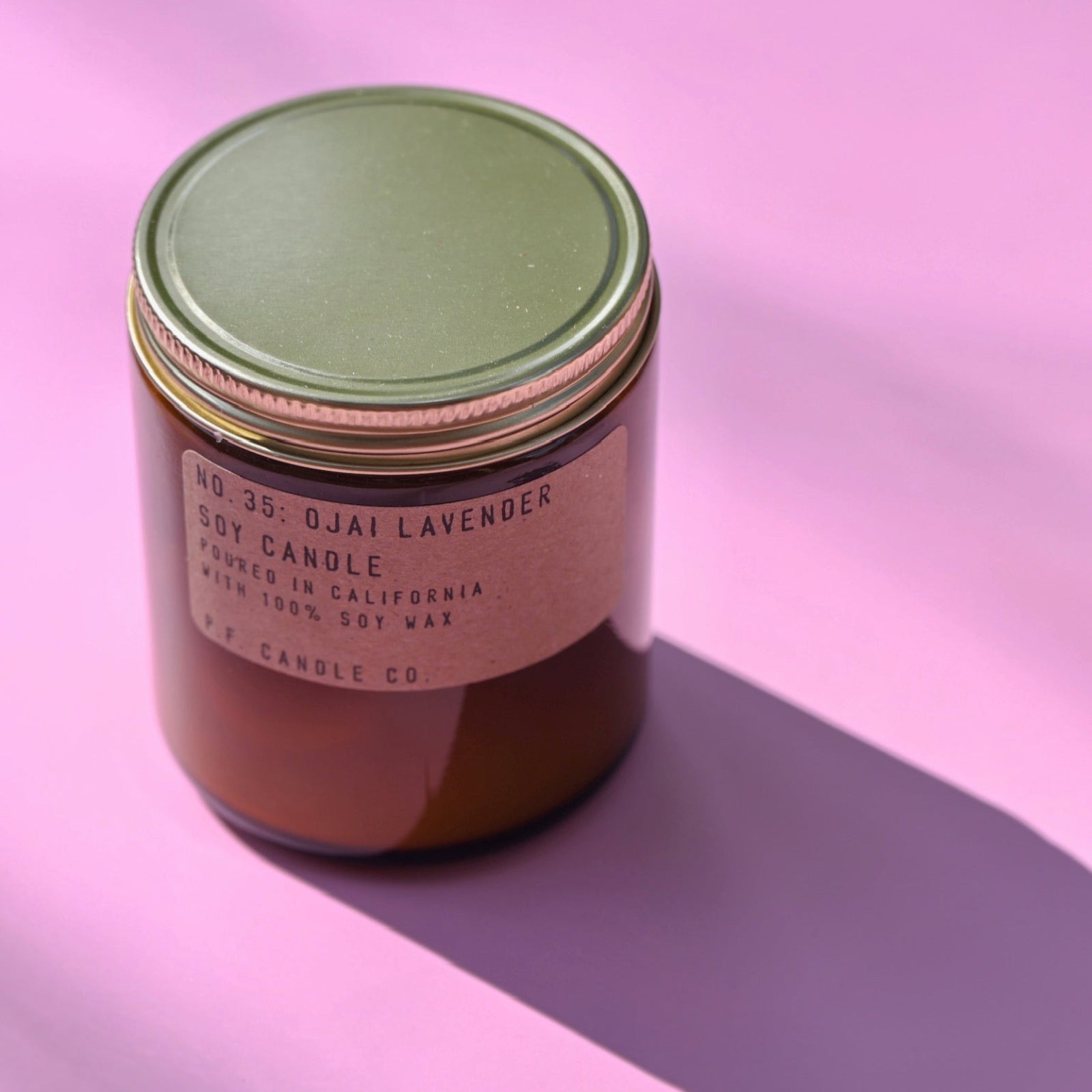 The P.F. Candle Co. Ojai Lavender - 7.2 oz Standard Soy Candle on a pink background.