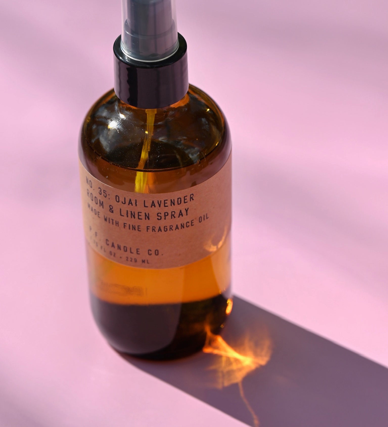 The P.F. Candle Co. - Ojai Lavender - 7.75 fl oz Room & Linen Spray on a pink background.