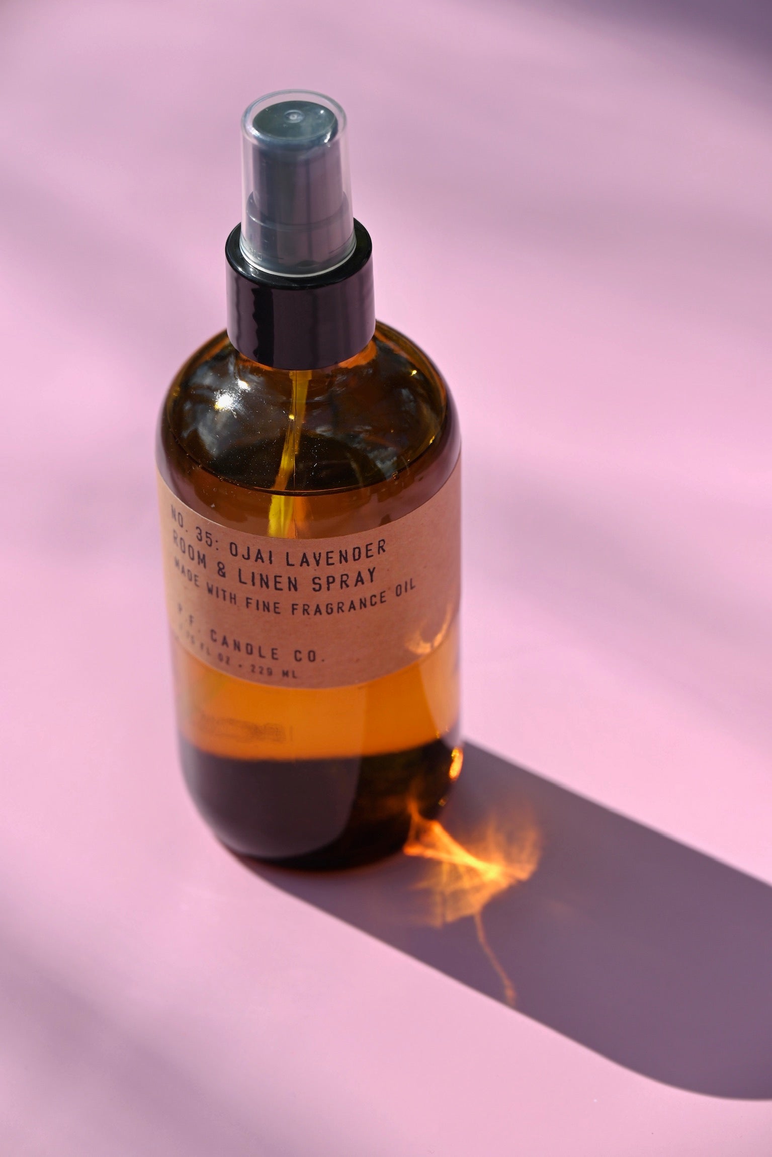 The P.F. Candle Co. - Ojai Lavender - 7.75 fl oz Room & Linen Spray on a pink background.