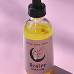 The Healer Potion Body Oil - Lavender Rose Body Oil on a pink background.