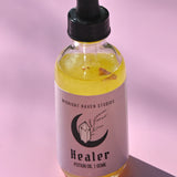 The Healer Potion Body Oil - Lavender Rose Body Oil on a pink background.