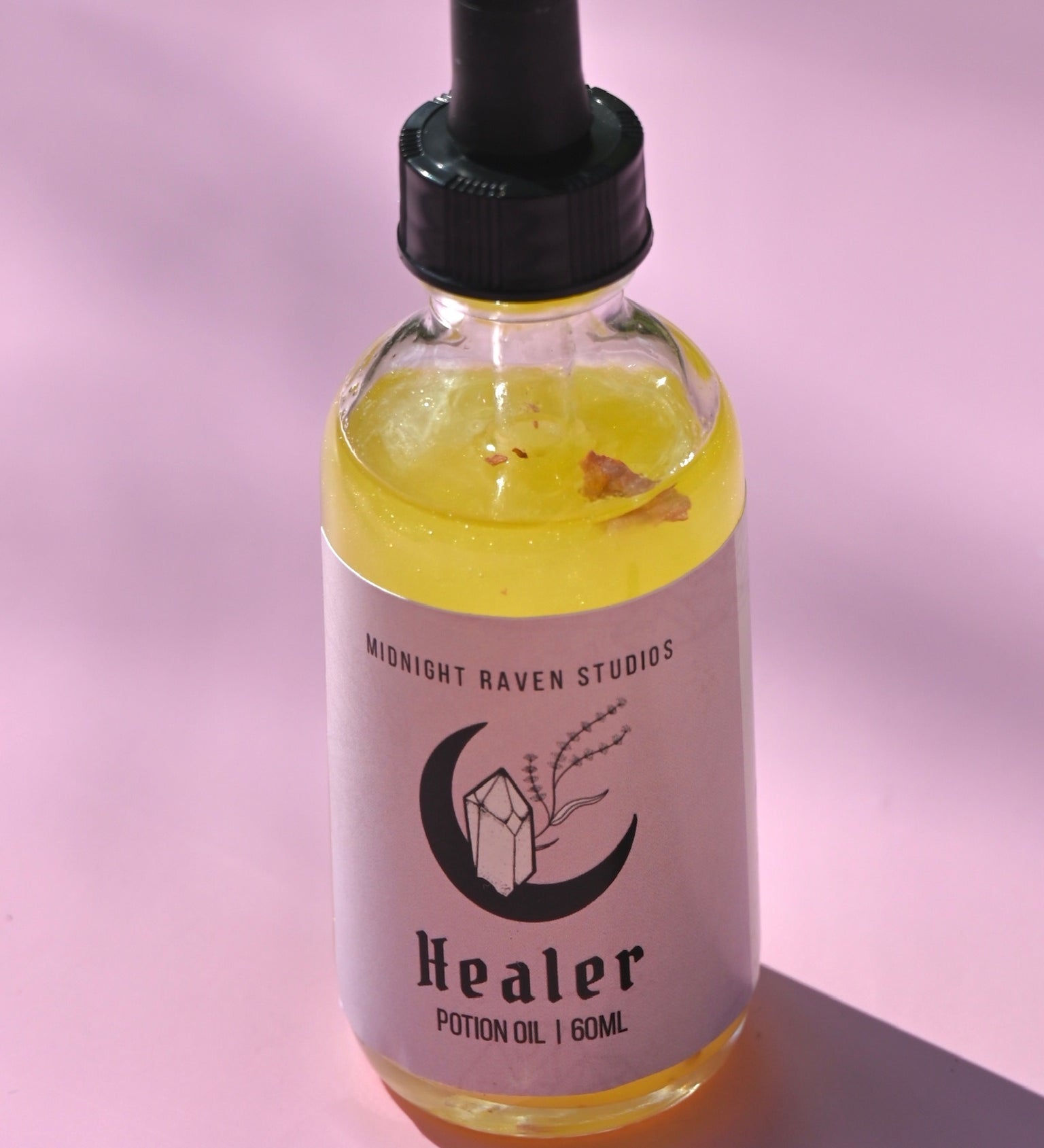 The Healer Potion Body Oil - Lavender Rose Body Oil on a pink background.