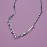 The Clear Quartz Stainless Steel Vibez Choker on a purple background.