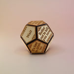 The Twelve Sided Single Divination Dice on a pink background.